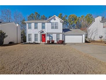 Two-story house with white siding, red door, and attached garage at 3945 Brushy Creek Way, Suwanee, GA 30024