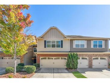 Two-story townhome with two-car garage and brick accents at 2297 Elmbridge Rd, Buford, GA 30519