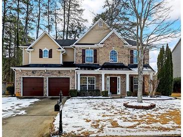 Brick two-story house with a three-car garage and a landscaped yard at 679 Crosswinds Cir, Marietta, GA 30008