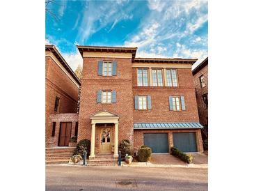 Charming brick townhome with blue shutters and a two-car garage, showcasing classic architectural details at 5890 Bond St, Cumming, GA 30040