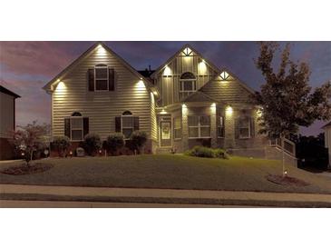 Attractive two-story home with brick and siding exterior, landscaping, and nighttime lighting at 45 Silver Peak Dr, Covington, GA 30016