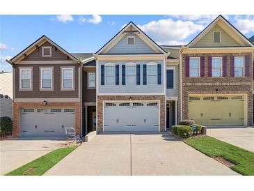 Three-unit townhome community; two-story homes with attached garages and landscaping at 108 Kasey Dr, Woodstock, GA 30189