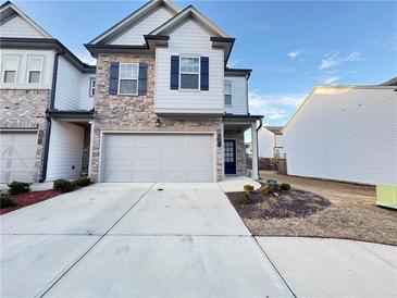 Two-story townhome with stone and white siding, two-car garage, and landscaping at 1394 Ben Park Way, Grayson, GA 30017