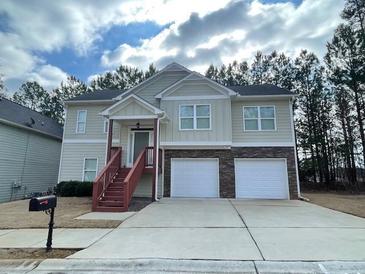 Two-story house with a two-car garage and a red wooden staircase at 113 Omega Ct, Dallas, GA 30157