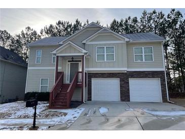 Two-story house with tan siding, two-car garage, and a red staircase at 113 Omega Ct, Dallas, GA 30157