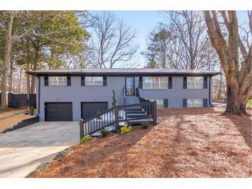 Gray exterior boasts a charming ranch design, two-car garage, and modern updates at 1810 Kinridge Rd, Marietta, GA 30062