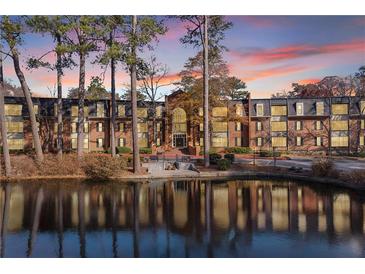 Attractive brick building with pond reflection at sunset at 23304 Plantation Ne Dr # 304, Atlanta, GA 30324