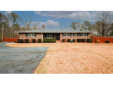 Brick ranch house with a large yard and driveway at 4924 River Rd, Ellenwood, GA 30294