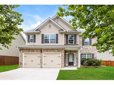 Two-story brick home with a large front yard and two-car garage at 4001 Village Crossing Cir, Ellenwood, GA 30294