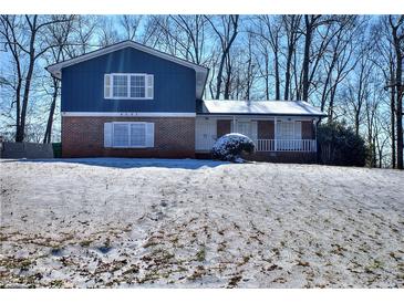 Brick and blue-sided house with a snow-covered yard at 4593 Bexley Way, Stone Mountain, GA 30083