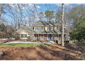 Two-story house with brick facade, covered porch, and landscaped yard at 134 Shadow Lake Sw Dr, Lilburn, GA 30047