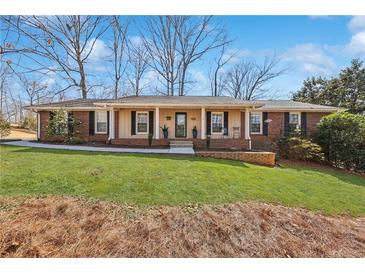 Charming brick home with a well-manicured lawn and inviting front porch at 3660 Hickory Se Cir, Smyrna, GA 30080