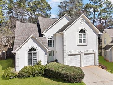 Charming two-story home with a stucco exterior, well-manicured lawn, and a two-car garage, perfect for suburban living at 3812 Chalmers Ct, Clarkston, GA 30021