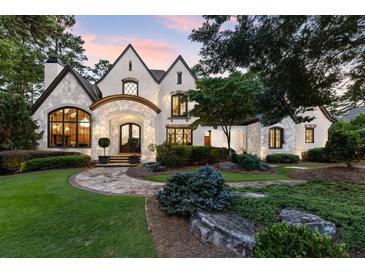 Charming two-story home with stone and brick accents, arched entry, and professional landscaping at 4874 Kettle River Pt, Suwanee, GA 30024
