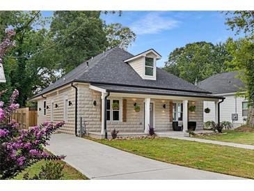 Charming stone home featuring a welcoming front porch, gray roof, and well-manicured front yard and walkway at 199 Racine Sw St, Atlanta, GA 30314