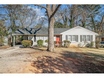Charming one-story house with red door, mature tree, and spacious yard at 1603 Hollyhock Ter, Decatur, GA 30032