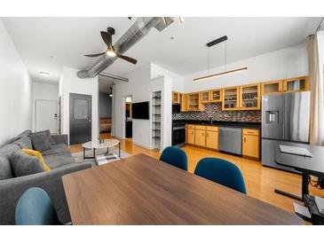 Open living area with hardwood floors, gray sectional sofa, and large windows at 800 Peachtree Ne St # 8607, Atlanta, GA 30308