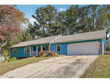 Ranch style home with blue siding, gray roof, and a two-car garage at 434 Cana Of Galilee Ct, Tucker, GA 30084