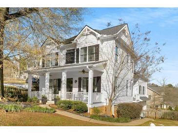 Two-story white house with wraparound porch, landscaping, and a large tree in the front yard at 1399 Knob Hill Se Ct, Atlanta, GA 30316