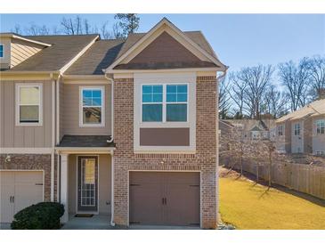 Brick front townhouse with 2-car garage and landscaped yard at 5531 Pine Aly, Lithonia, GA 30058