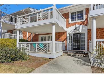 Charming brick building with white trim, balcony and porch with walkway to black-framed glass entry door at 885 Briarcliff Ne Rd # 21, Atlanta, GA 30306
