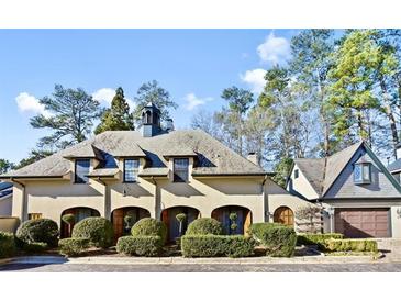 Charming French-style home with manicured landscaping and a stone driveway at 23 Paces West, Atlanta, GA 30327