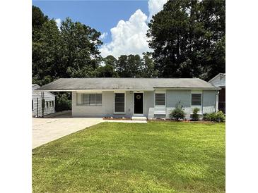 Charming home with a well-maintained front lawn and grey painted brick exterior and a carport at 2649 Santa Barbara Nw Dr, Atlanta, GA 30318