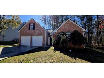Charming brick home featuring an attached two-car garage and a well-manicured lawn at 1432 Cutters Mill Dr, Lithonia, GA 30058