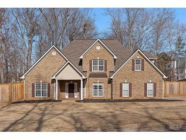 Brick two-story house with a large front yard and a wooden fence at 1105 Huntcrest Rdg, Mcdonough, GA 30252