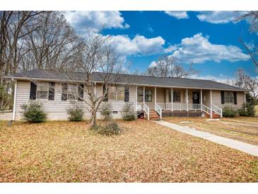 Ranch-style home with front porch and mature trees at 134 N Johnson N St, Newborn, GA 30056