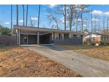 Charming single-story home featuring a covered carport, a long driveway and freshly painted exterior at 3413 Canadian Way, Tucker, GA 30084