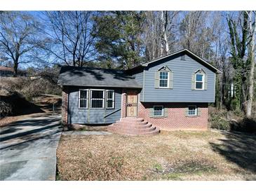 Brick and gray sided two-story house with a small front yard and steps leading to the entrance at 2761 Rockdale, Decatur, GA 30034