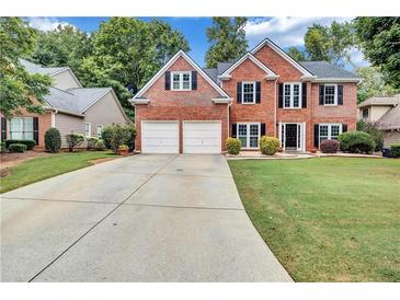 Brick house with 2-car garage and landscaped lawn at 1450 Grovehurst Dr, Marietta, GA 30062