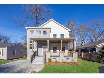 Two-story home with gray brick and white accents, front porch, and landscaped lawn at 1565 Pineview Terrace Sw, Atlanta, GA 30311