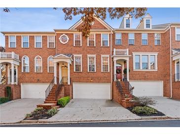 Brick front exterior of a three-story townhome with attached garage and landscaping at 2428 Bridlewood Se Dr # 24, Atlanta, GA 30339