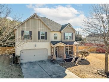 Two-story house with brick and siding, attached garage, and rocking chairs on the porch at 502 Starling View Cir, Grayson, GA 30017