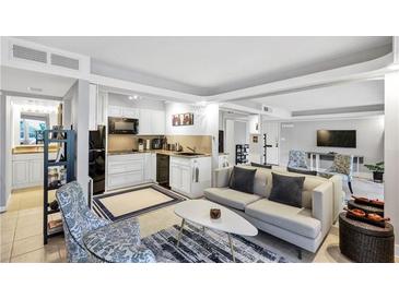 Open-concept living room and kitchen featuring sleek white cabinets and modern appliances at 141 Maison Nw Pl, Atlanta, GA 30327