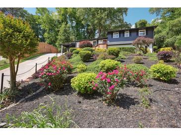 Charming home with a beautiful yard featuring meticulously designed landscaping and colorful flowerbeds at 2139 Cedarbrook Se Ct, Atlanta, GA 30316