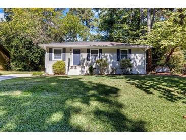 Ranch style home with a well-manicured lawn and mature trees at 1003 Springdale Dr, Marietta, GA 30062