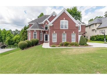 Brick house with a large green lawn and driveway at 2080 Misty Oaks Dr, Buford, GA 30519