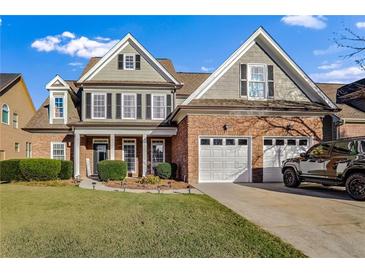 Two-story house with a brick facade, two-car garage, and landscaped lawn at 169 Blue Creek Ln, Loganville, GA 30052