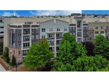 Modern apartment building with brick and stone accents, surrounded by lush green trees at 390 17Th Nw St # 4063, Atlanta, GA 30363