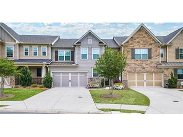 Two-story townhome with attractive landscaping and a two-car garage at 2475 Barley Crest Pass, Cumming, GA 30040