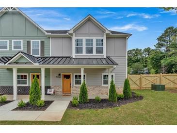 Two-story townhome with gray and green siding, a metal roof, and a front porch at 702 Fairgate Rd, Marietta, GA 30064