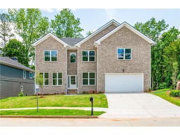 Two-story brick home with a white garage door and landscaped lawn at 5649 Eagles Watch, Douglasville, GA 30135