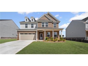 Charming two-story home featuring a brick facade, well-manicured lawn, and attached two-car garage at 313 Foxglove Way, Mcdonough, GA 30253
