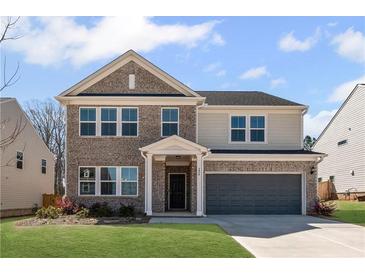 Charming two-story home with a brick and siding exterior, a well-manicured lawn, and an attached two-car garage at 236 Begonia Way, Mcdonough, GA 30253