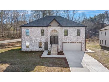 Two-story brick home with a large driveway and attached garage at 4400 Ross Estates Ct, Snellville, GA 30039
