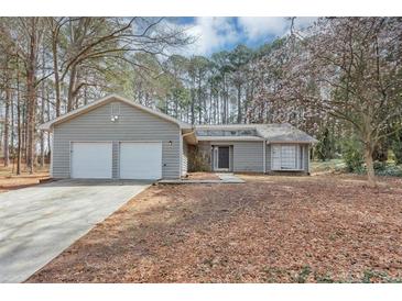 Charming single-story home with a two-car garage and inviting curb appeal in a wooded setting at 7018 Chimney Ridge Dr, Riverdale, GA 30296