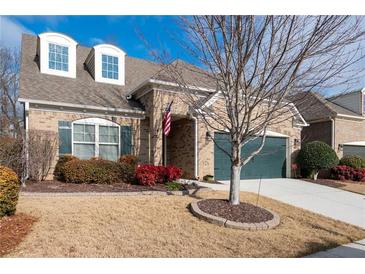 Brick home with 2-car garage, landscaping, and a welcoming front porch at 121 Meridian Dr, Woodstock, GA 30188